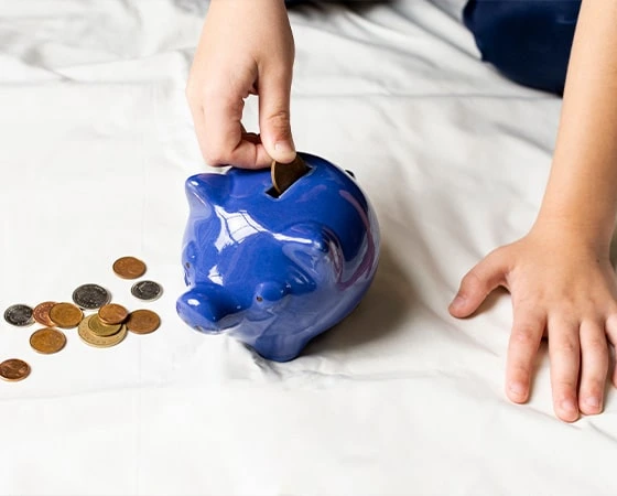 Gyerek keze és malacpersely, megtakarítás gyerekeknek.