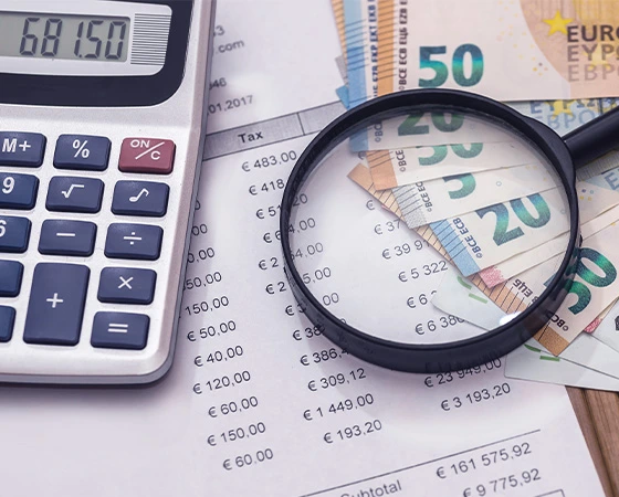 Bankjegyek, számológép és pénzügyi kimutatások nagyítóval. Adóoptimalizált befektetések.